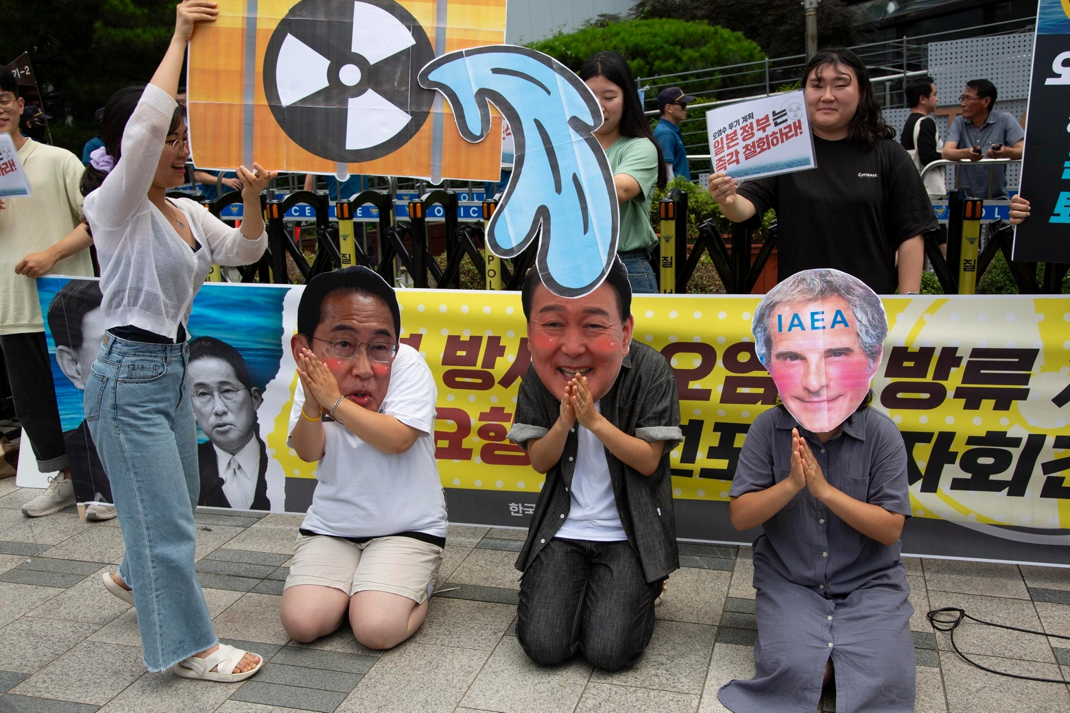 Fukushima, protesta in Corea del Sud contro il piano di sversamento in mare. Studenti mascherati dal presidente giapponese Kishida, il sudcoreano Yoon Suk-Yeol e il direttore dell'Aiea Grossi (Ansa)