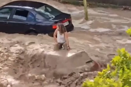 Un frame da un video dell'alluvione a Saragozza con le persone sopra le auto